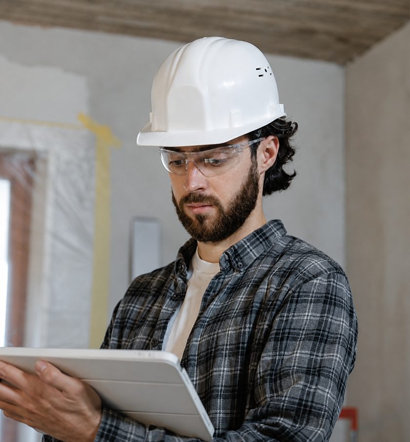 Engineer wearing a hard hat reviewing plans