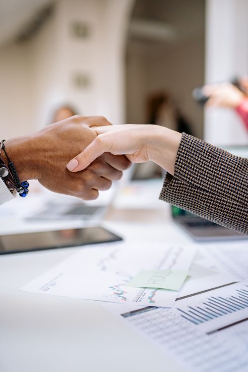 Two people shaking hands across a table